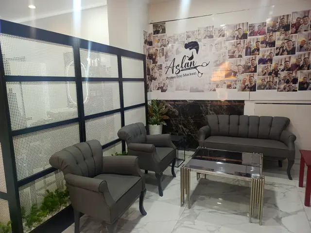 Gri koltuklar ve sehpanın olduğu bekleme salonu